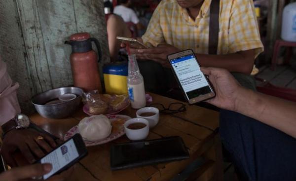 Myanmar people gather for refreshement at a teashop in Yangon many hangout to chat and browse Facebook with their mobile phone. Photo: Sai Aung Main/AFP