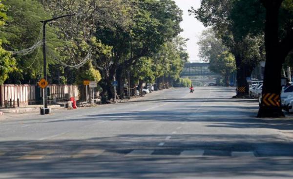 A woman crosses the empty street in downtown Yangon, Myanmar, 10 December 2021. Photo: EPA