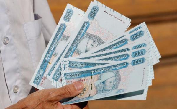 A man holds new edition of 1,000 Myanmar Kyats banknotes featuring portrait of late General Aung San outside the Myanmar Economic Bank in Yangon, Myanmar, 07 January 2020. Photo: Nyein Chan Naing/EPA