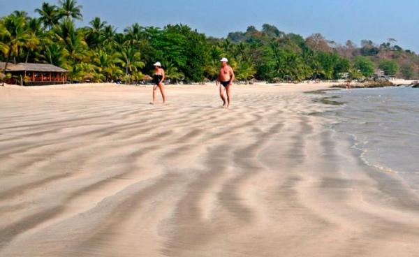 Foreign tourists walk along Ngapali beach, on the Bay of Bengal, west coast of Myanmar. Photo: EPA