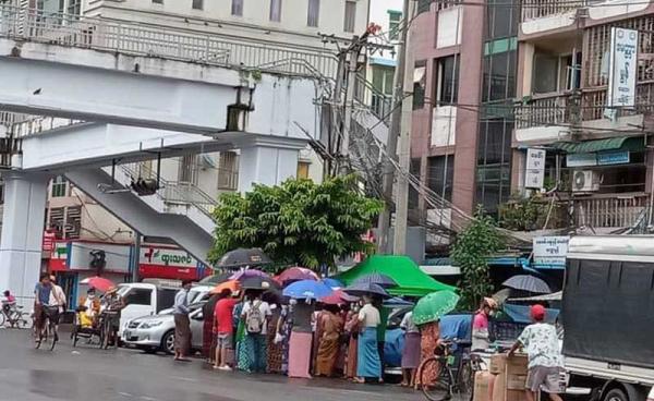 People queue to buy medicine at a pharmacy in Yangon. (Photo: CJ)