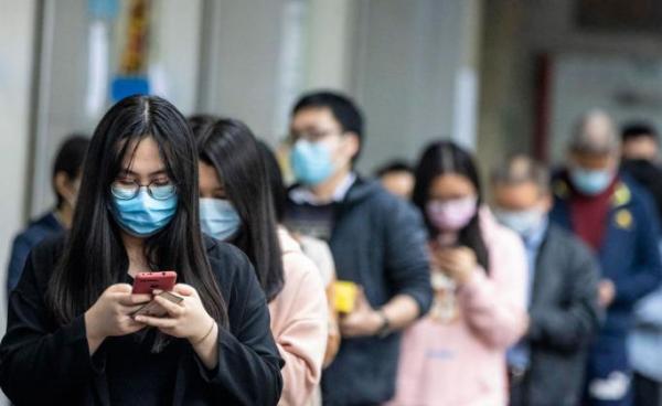 People queue outside a pharmacy as they won the lottery to buy protective masks, in Guangzhou, China, 13 February 2020. Photo: EPA