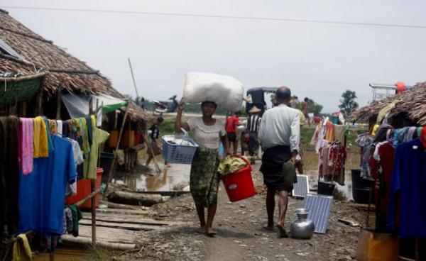 A woman carries a bag as she walks near the Tin Nyo village's internally displaced persons (IDP) shelter in Mrauk U township area, Rakhine State, western Myanmar, 15 July 2019. Photo: Nyunt Win/EPA