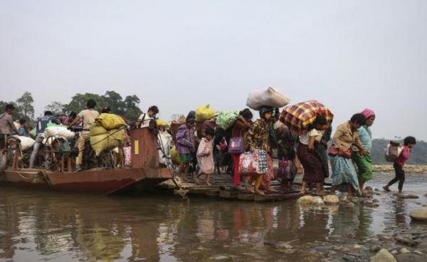 This picture taken on April 26, 2018 shows displaced Kachin residents crossing Malikha river on a ferry to escape the fighting in Injanyan village near Myitkyina between the Kachin Independence Army, ethnic armed group against the Myanmar government troops in Myanmar's northernmost state of Kachin near the border with China. Photo: Zau Ring Hpra/AFP