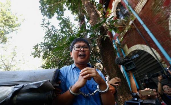 (File) Reuters' journalist Wa Lone in handcuffs talks to the media as he leaves the court after the first trial in Yangon, Myanmar, 10 January 2018. Photo: Lynn Bo Bo/EPA