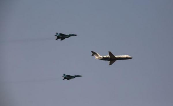 Myanmar Air Force fighter jets accompany an airplane during a display to celebrate Myanmar's 77th Armed Forces Day in Naypyidaw on March 27, 2022.Photo by AFP