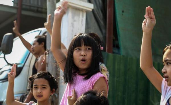 Children flash the defiant three-finger salute as demonstrators march during an anti-military coup protest in Mandalay, Myanmar. Photo: EPA