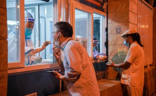 A medical worker takes a swab sample from a man in Beijing, China, 02 September 2022. Photo: EPA