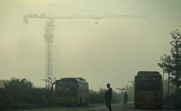 A man crosses a street amid high levels of air pollution in Yangon on January 27, 2025. (Photo by Sai Aung MAIN / AFP)