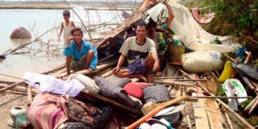 A Myanmar family sits on the remains of their house in Bogolay, the Irrawaddy Delta, 14 May 2008. Photo: EPA